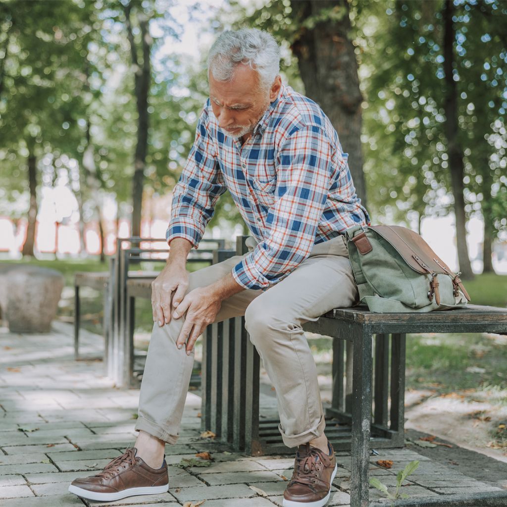 mature-man-sitting-on-bench-knee-pain-1175031650-web-1